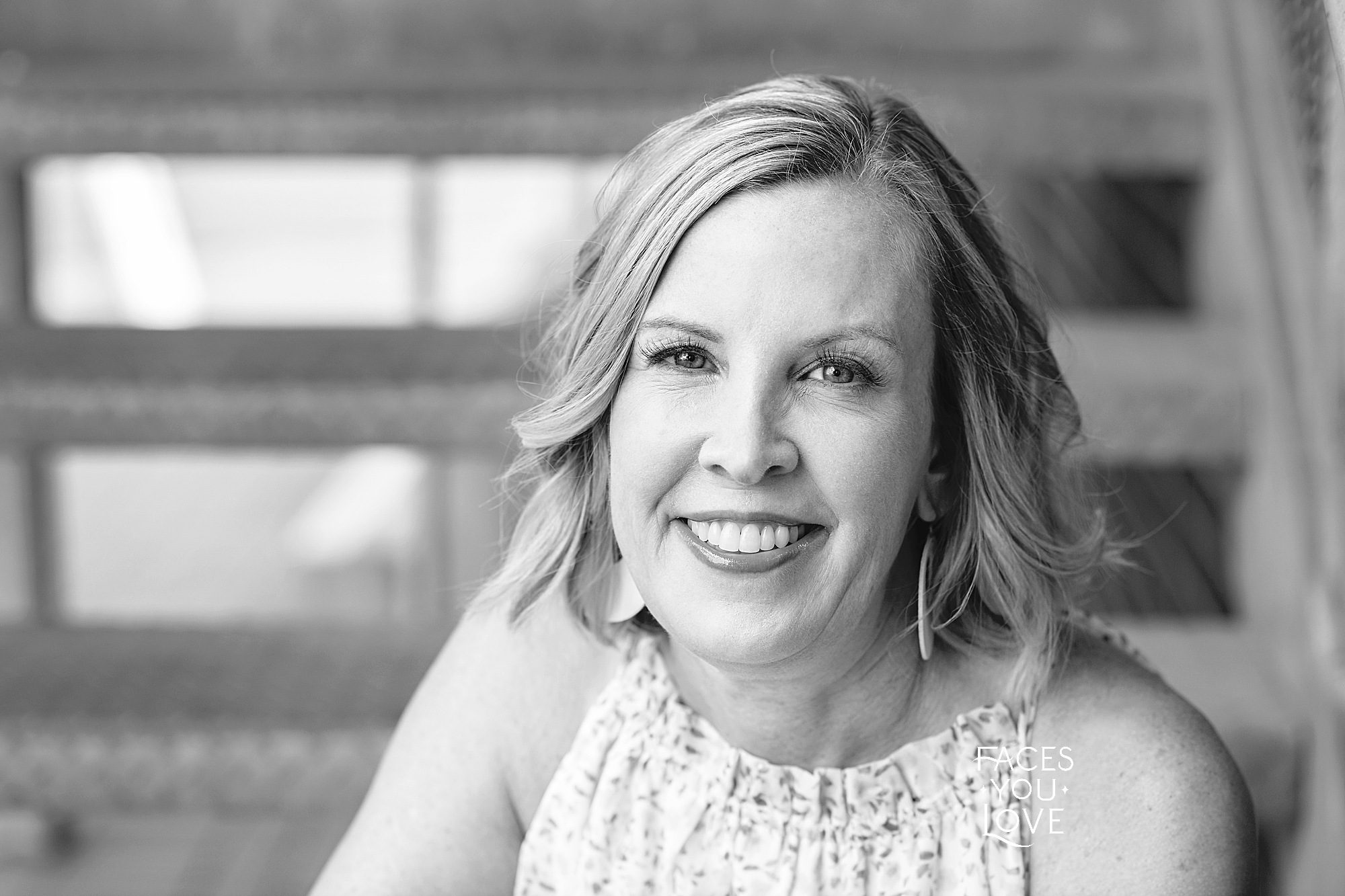 Black and white close up headshot of a woman in Kansas City. Photographed on metal steps, outdoors, by Faces You Love Photography.