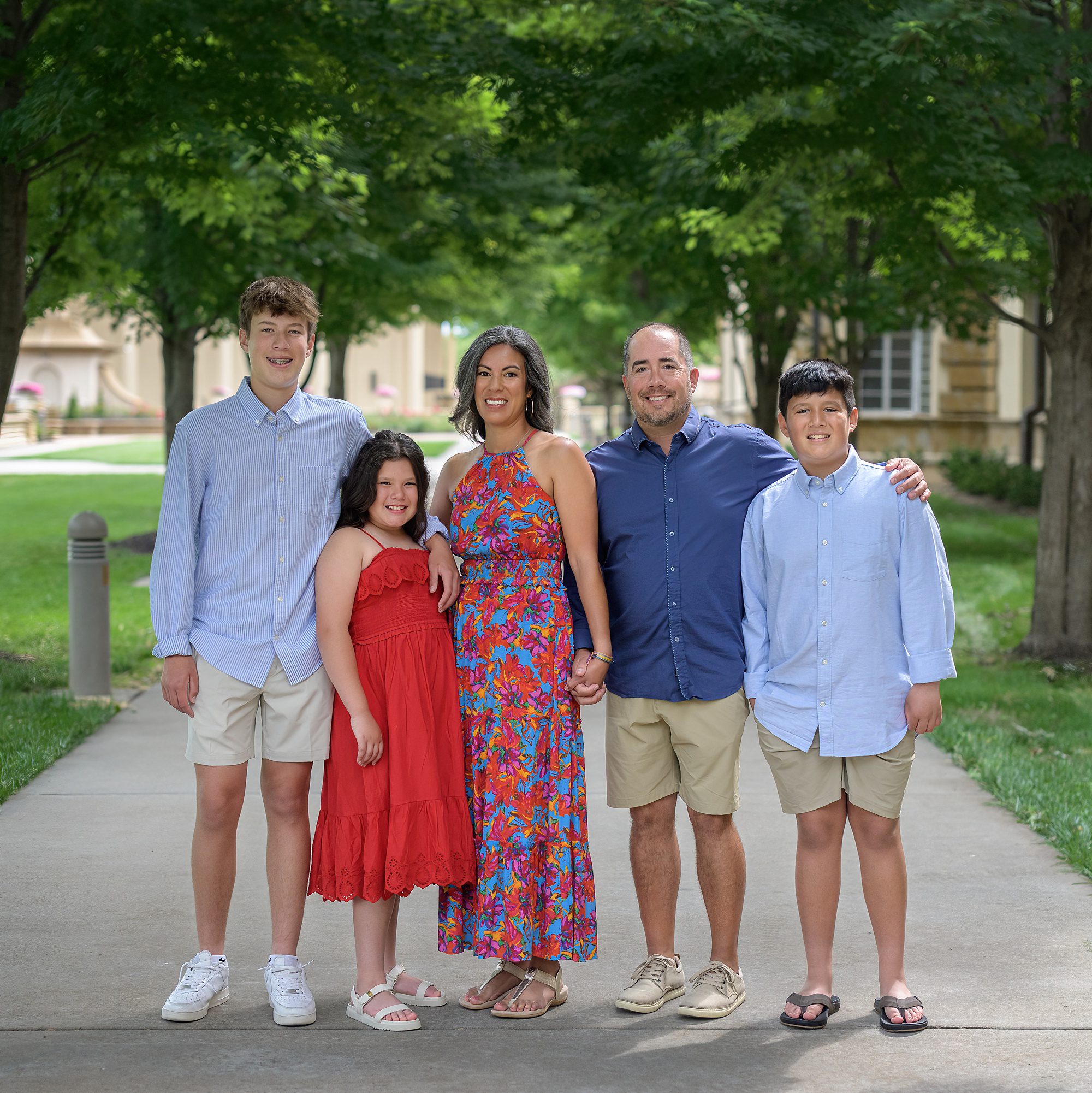 Family of five posing during the summer at Unity Village in Missouri, photographed by one of the best family photographers in Kansas City, Helen Ransom.