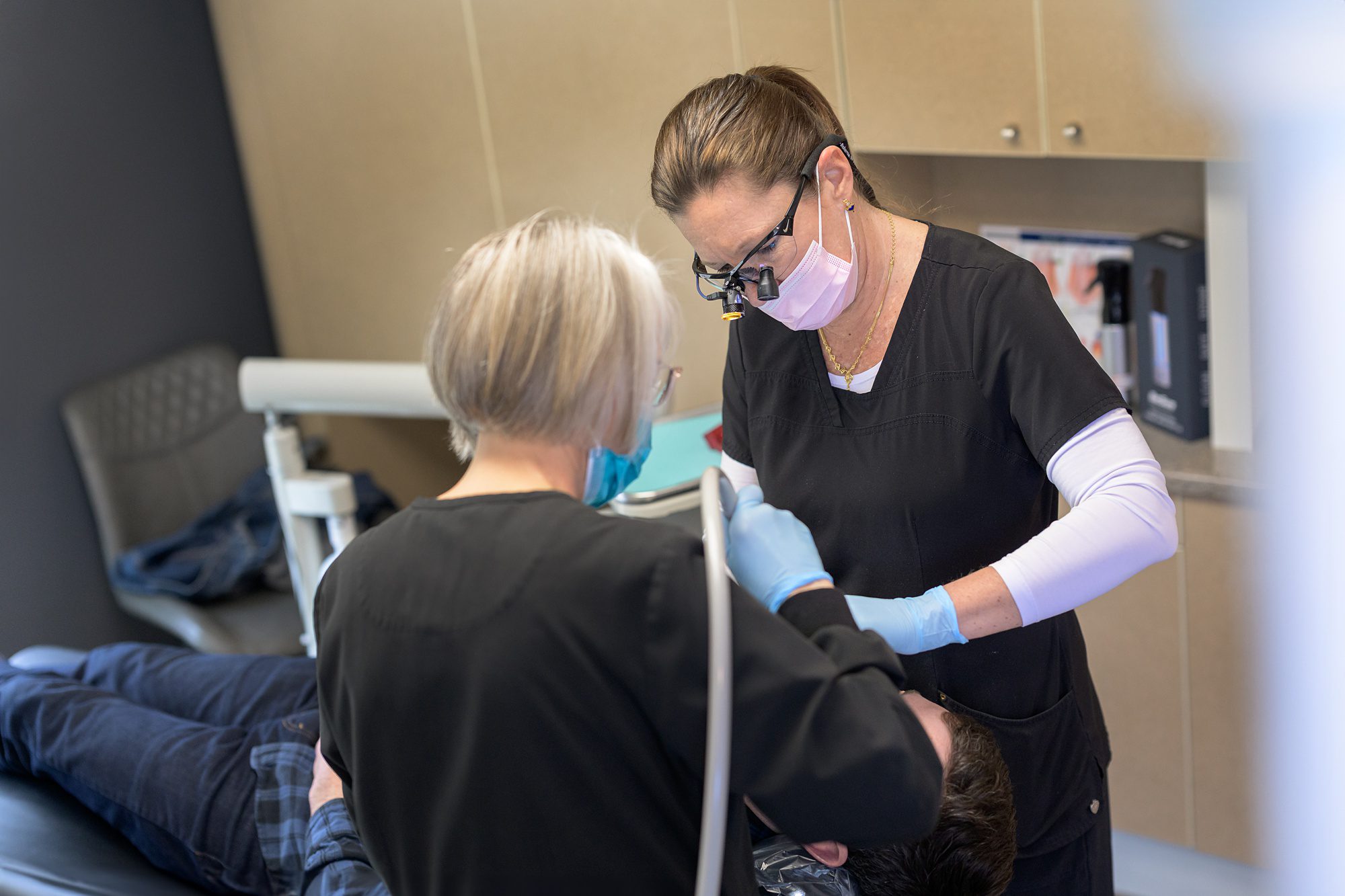 Dentist and assistant working on a patient during the business' commercial branding session in Kansas City.